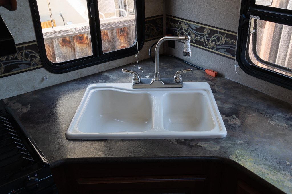 White double sink and faucet on RV kitchen counter