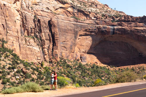 People taking selfie at foot of arch in the making cliff