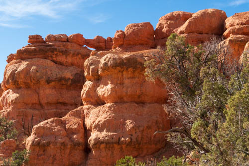 Red rock formations, arch, and blue sky