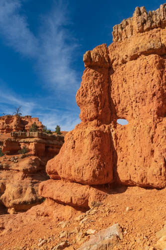 Red rock formations, hole in the rock, blue skies, wispy clouds