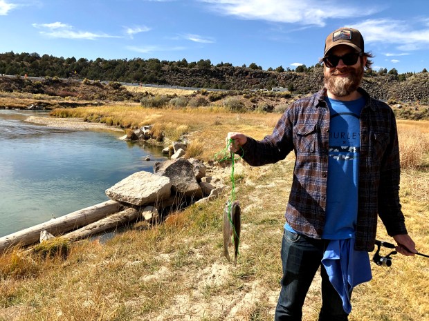 Man with beard holding two fish on a stringer