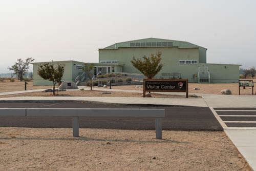 Desert landscape with large green building and signs