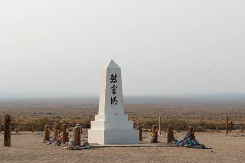 White obelisk with black Japanese characters, Soul Consoling Tour, smoky skies