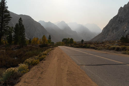 Road leading to mountain peaks shrouded in smoke