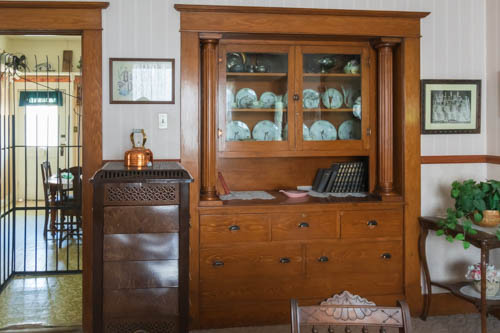 Dining room inside early 1900s home, with wood built-in hutch and buffet