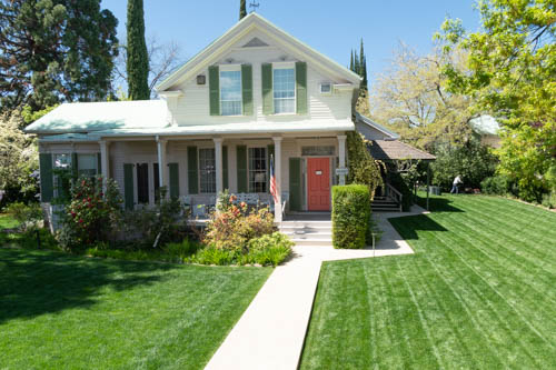 1800s style home with manicured green grass