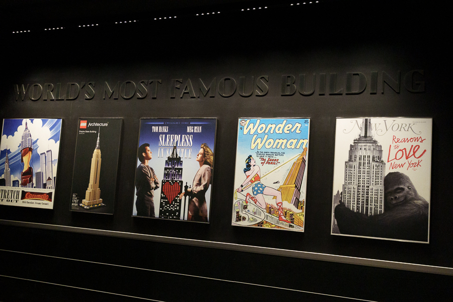 Exhibit featuring posters showcasing famous depictions of the Empire State Building, including movie posters and comic art, with the title 'WORLD'S MOST FAMOUS BUILDING' displayed prominently.