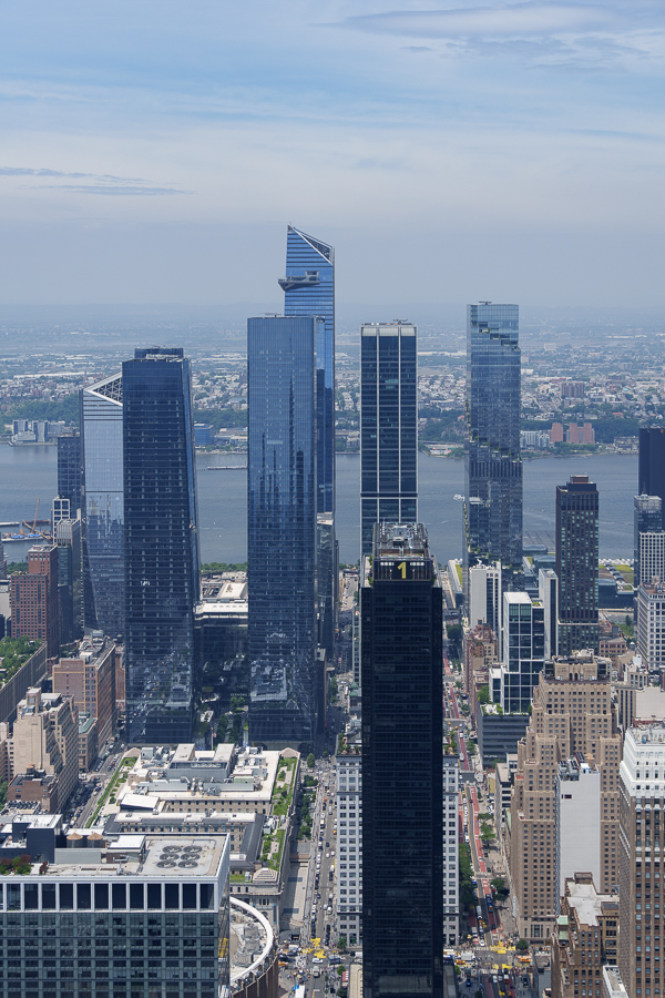 Aerial view of modern skyscrapers in a city skyline with a river in the background.